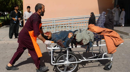 A humanitarian official transports wounded Afghan civilian from site of Bus bombing on the Kandahar-Herat Highway. Image Source: Al Jazeera