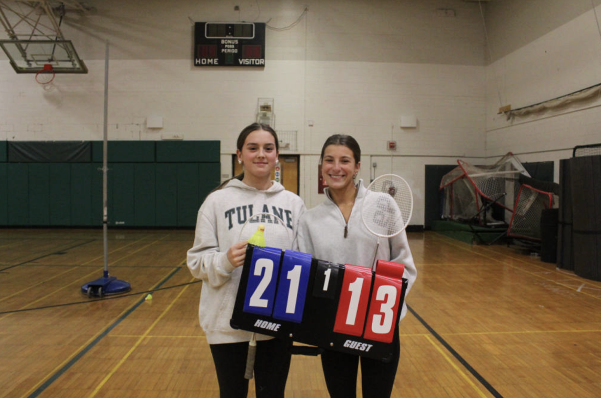 Julia and Caitlin stand victorious after their final match, holding the score.